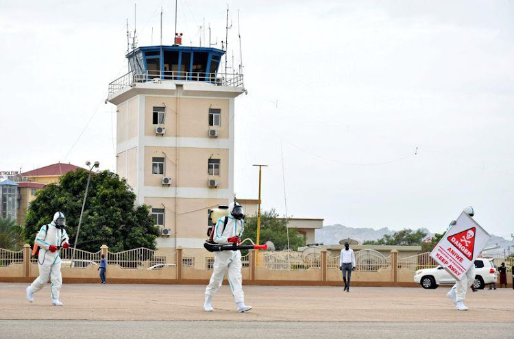 Members of a medical team wearing protective suits clean the airfield, to prevent the spread of the coronavirus disease (COVID-19), at the Juba International Airport in Juba, South Sudan April 5, 2020. REUTERS/Jok Solomun