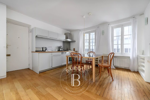 Open kitchen with table and chairs in this luxury apartment / penthouse for sale in Paris 1er ($784,337 - 52 m²)
