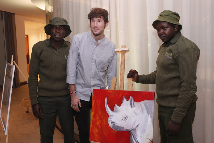 Starring character Ol Pejeta warden Joseph Mwenda with film director David Hambridge and co-star Joseph Wachira, posing with a rhino mural