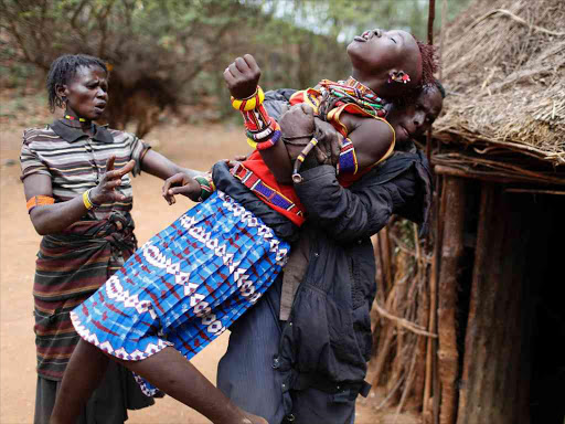 UNWILLING BRIDE: A girl is restrained in Marigat, Baringo County after trying to escape when she realised that she had been married off, December 7, 2014. /REUTERS