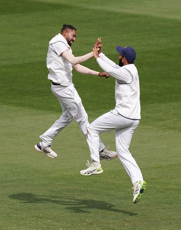 India's Mohammed Siraj celebrates with Cheteshwar Pujara after taking the wicket of Travis Head of Australia during day three of the second test match between Australia and India