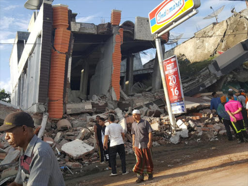 People survey the damage after dozens of buildings collapsed following a 6.4 magnitude earthquake in Ule Glee, Pidie Jaya in the northern province of Aceh, Indonesia December 7, 2016. /REUTERS