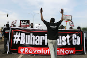 Protesters carry placards and banners during a June 12 Democracy Day rally in Abuja, Nigeria, on June 12 2021. 