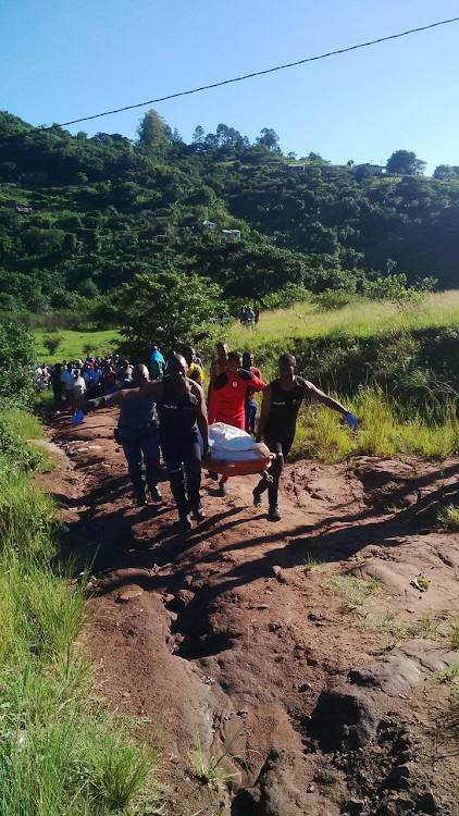 Specialized police Search and Rescue Unit divers carry the body of a drowning victim out a ravine in Ndwedwe.