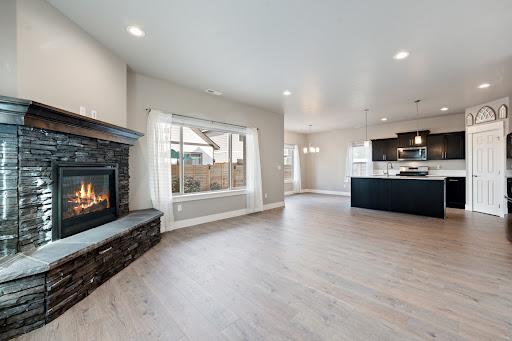 Modern living room with stone fireplace and open kitchen in this luxury house for sale in Bend ($595,000 - 199 m²)
