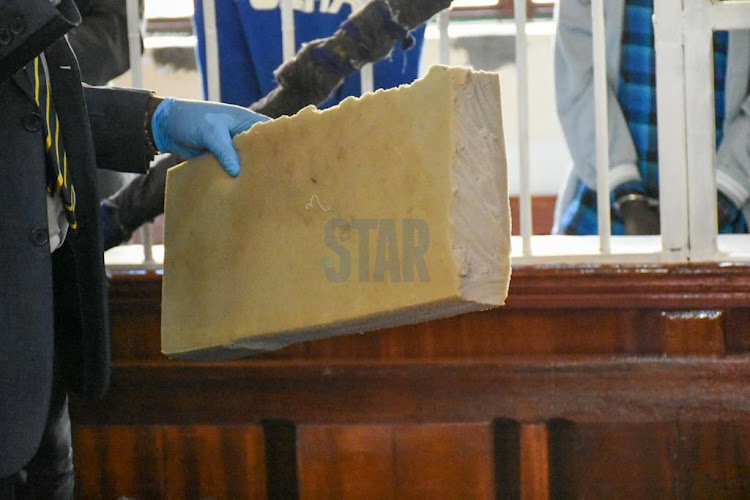 The prosecutor hold a Rectangle shaped piece of mattress that was used to cover the hole at Kamiti Prison where the accused escaped from at Kahawa law court on 29, November 2021 before Chief Magistrate Diana Mochache./ MERCY MUMO