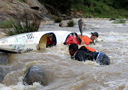 Canoeists capsize as they paddle down rapids on the first day of the Dusi. 