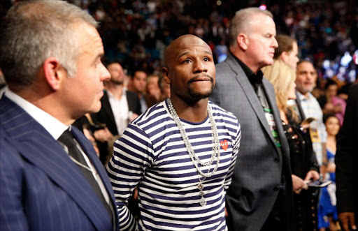 Former boxing champion Floyd Mayweather Jr. (C) waits for the start of the WBA featherweight title fight between Carl Frampton and Leo Santa Cruz at MGM Grand Garden Arena on January 28, 2017 in Las Vegas, Nevada.