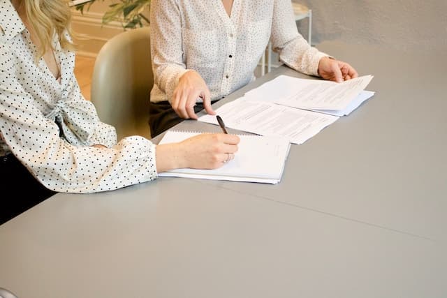 2 women working on AOB contract