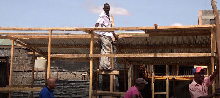 Carpenters at work at the Garissa market stalls that were burnt last week.