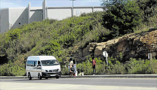 BREAKING THE LAW: A taxi stops for hitchhikers along the forbidden R61 route near the Mthatha Circus Triangle mall Picture: SIKHO NTSHOBANE