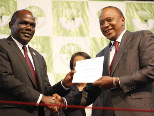 IEBC chairman Wafula Chebukati hands President Uhuru Kenyatta his certificate following the announcement of the winner of the repeat election, October 30, 2017. /MONICAH MWANGI