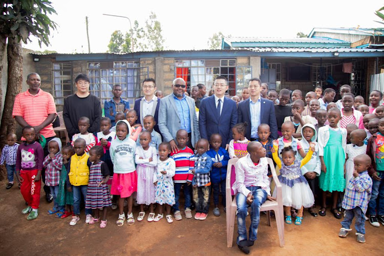 Mr. Ma Chengyuan, Chief Representative of AVIC International Holding Corporation in Kenya together with Mutuini MCA Mr. Martin Mbugua and other dignitaries interact with children at Shiphrah Centre in Mutuini Ward, Dagoretti South constituency in Nairobi, after donating a solar system to the institution.