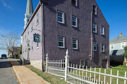 Old house with purple siding and white fence in this luxury house for sale in Lunenburg ($460,802)
