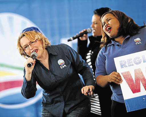 Helen Zille, premier of the Western Cape, and Lindiwe Mazibuko, parliamentary leader of the Democratic Alliance, sing with local artist Lauren Erasmus at the DA's launch of its registration campaign in Mitchells Plain, Cape Town. File photo.