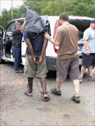 NABBED: Police with the suspect in Swazi leader Gabriel Mkhumane's murder. Pic. Riot Hlatshwayo. 28/10/2008. © Sowetan.