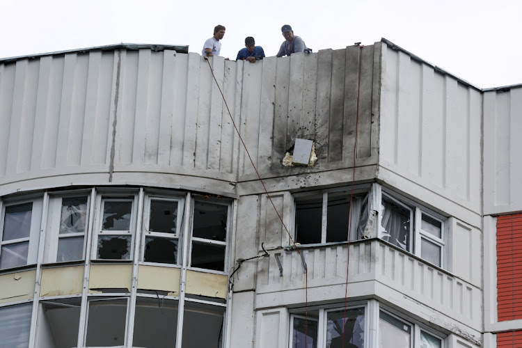 Men are seen on the roof of a damaged multi-storey apartment block following a reported drone attack in Moscow, Russia, on May 30 2023. Picture: MAXIM SHEMETOV/REUTERS