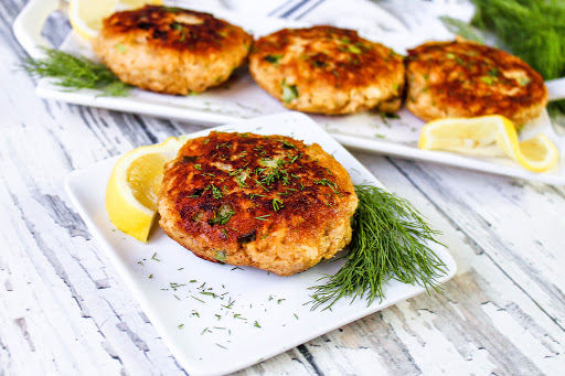 Canned Salmon Patty on a plate with lemon and dill.