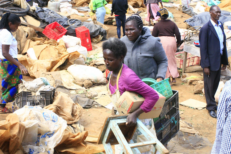 Traders relocate their belongings after shanties were demolished in Kabarnet open air market in Baringo on Tuesday.