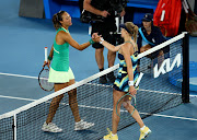 China's Qinwen Zheng (left) shakes hands with Ukraine's Dayana Yastremska after winning her semifinal match.