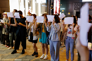 People hold sheets of paper in protest over coronavirus disease restrictions in mainland China, during a commemoration of the victims of a fire in Urumqi, in Hong Kong, China on November 28 2022. 
