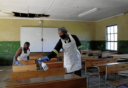 Tholiwe Hlophe, left, and Skhumbuzo Mchunu - parents at Sobonakhona Secondary School in Umbumbulu - disinfect a classroom as the school prepares to partially reopen.