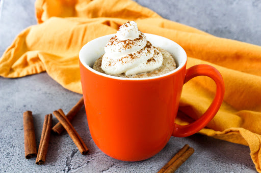 Cinnamon Swirl Snickerdoodle Mug Cake with cream cheese frosting on top.