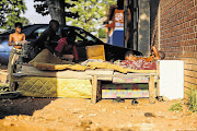 Children play on a damaged bed after an eviction in Jeppestown, Johannesburg.