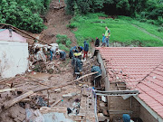 Search and rescue teams comb rubble for survivors after homes collapsed due to heavy rain and mudslides. File photo.