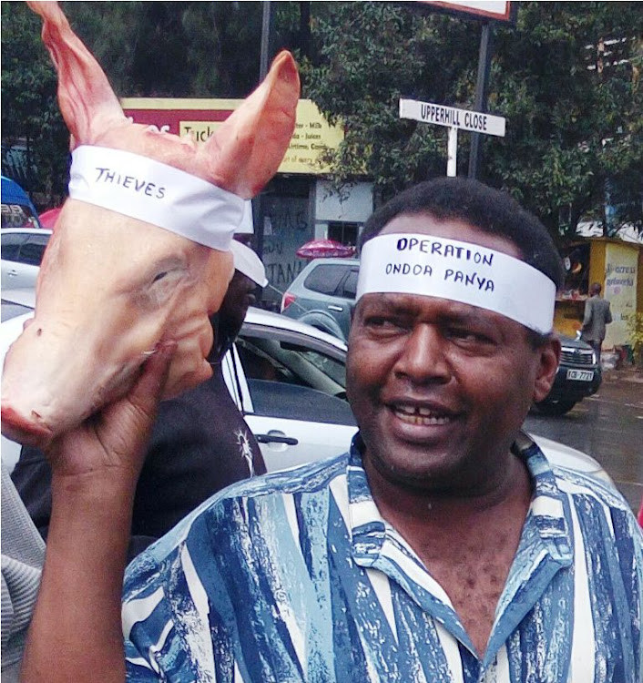 Human rights activist John Wamagata holding a pigs head on May 14, 2013 at Parliament buildings.