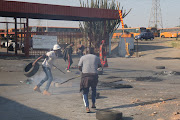 Striking Putco employees blocking the entrance to the bus depot in New Canada, Soweto, with burning tyres and rocks.