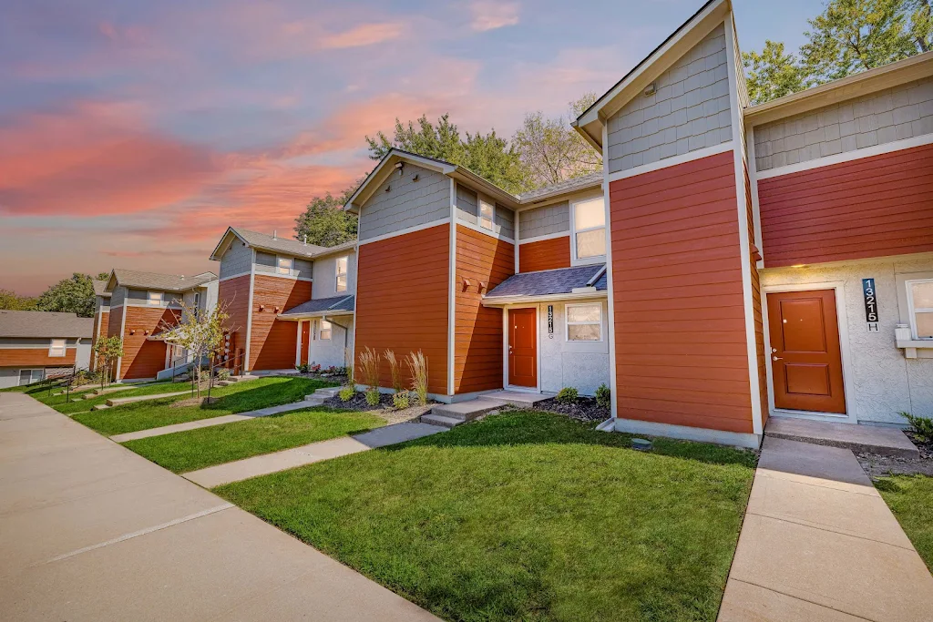 Photo of apartments with grassy lawn at sunset.