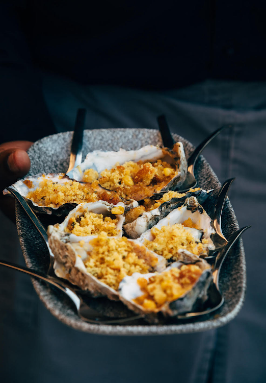 Smoked oysters with a tomato and onion compound butter finished with a crispy cornbread crumb.