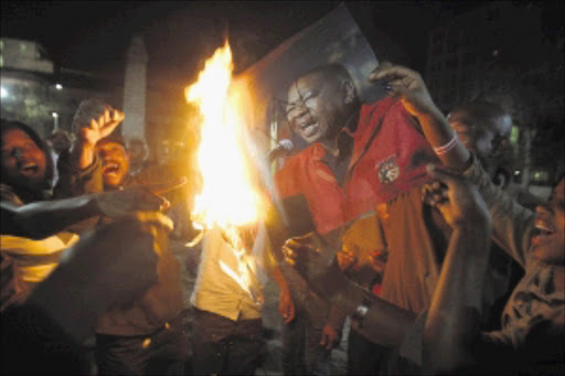 BLADE ON FIRE: ANCYL president Julius Malema's loyalists burn a Blade Nzimande poster at Beyers Naudé Square where they gathered to offer him support before his disciplinary hearing today. PHOTO: VELI NHLAPO