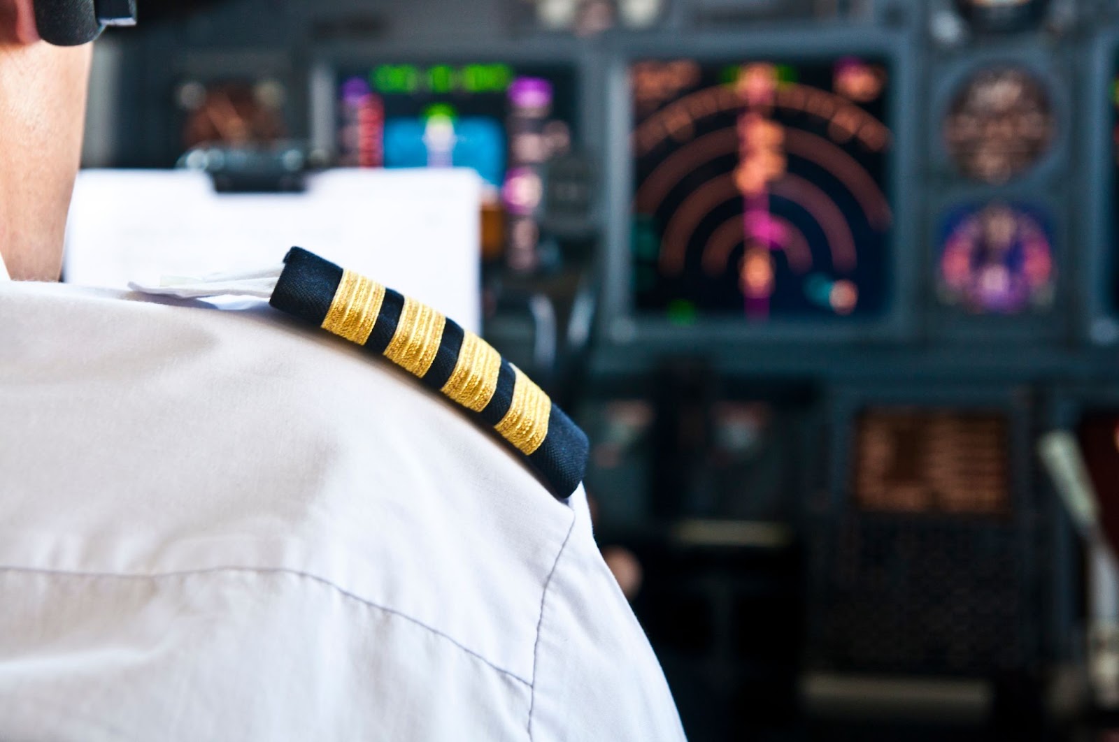 A pilot in the cockpit of a commerical airliner.