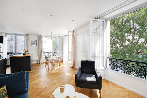 Bright living room with parquet floor and tree-lined balcony in this luxury property for sale in Paris 3ème ($1,026,287 - 57 m²)