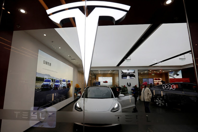 Visitors check a Tesla Model 3 car next to a Model Y displayed at a showroom of the US electric vehicle maker in Beijing, China. File photo: FLORENCE LO/REUTERS