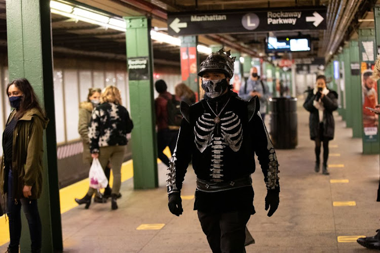 Commuters take the subway in costume on Halloween wearing masks as precautionary measure during the Covid-19 outbreak in Brooklyn, New York, US, on October 31 2020.