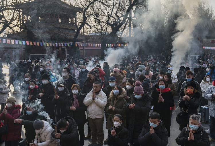 People gather to perform prayers for good fortune at Yonghegong, or the Lama Temple, for the Chinese Lunar New Year in Beijing, China, January 22 2023. Picture: KEVIN FRAYER/GETTY IMAGES