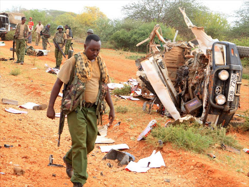 A security personnel member walks past a police vehicle damaged by a blast killing police officers at the Garissa county, May 24, 2017. /REUTERS