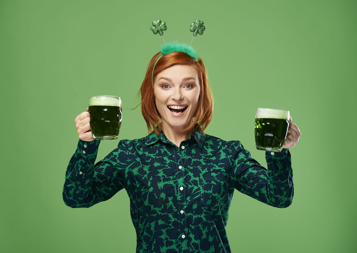 mulher segura dois canecos de cerveja verde