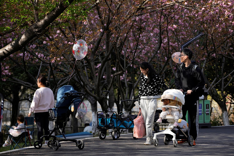 Parents pushes a stroller with a baby in a park in Shanghai, China, on April 2, 2023. REUTERS/ALY SONG