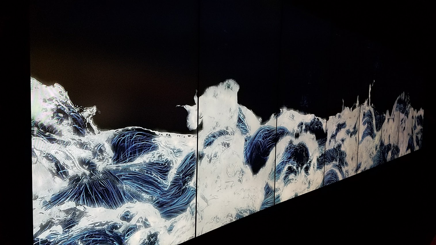 Black Waves as part of Pace Art + Technology exhibit Living Digital Spaces and Future Parks. The movement of waves of water is simulated in a computer-generated three-dimensional space. The water is expressed as a continuous body after calculating the interactions of hundreds of thousands of particles