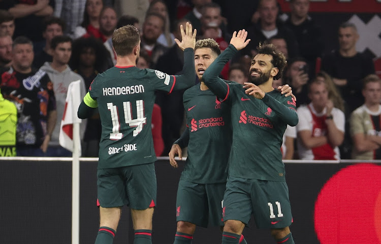 Mohamed Salah of Liverpool (right) celebrates his goal with Roberto Firmino, Jordan Henderson during the Uefa Champions League group A match against AFC Ajax Amsterdam at Johan Cruyff \ArenA in Amsterdam on October 26 2022.