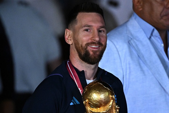 Argentina's captain and forward Lionel Messi holds the Fifa World Cup Trophy upon arrival at Ezeiza International Airport in Buenos Aires on December 20 2022 after winning the Qatar 2022 World Cup tournament.