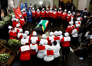 Women in church uniforms gather around the coffin of police diver Sgt Busisiwe Mjwara, who died while searching for flood victims, at her official funeral in Pietermaritzburg on April 22 2022. 