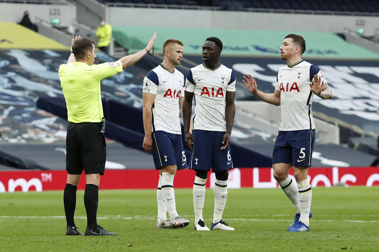 Tottenham Hotspur's Eric Dier, Pierre-Emile Hojbjerg and Davinson Sanchez react after referee Peter Bankes awards a penalty to Newcastle United upon VAR review.