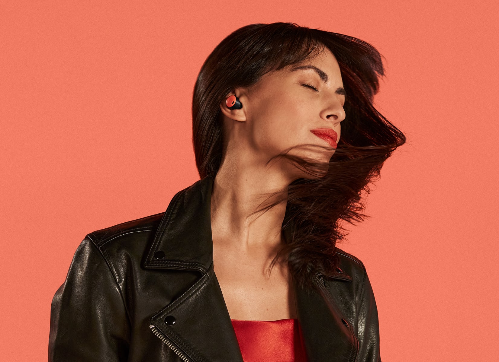 A person in a leather jacket dances to music playing in their Coral Pixel Buds Pro