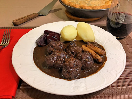 Delicious dish from Québec with meatballs, pork sausage, boiled potatoes and pickled beets.