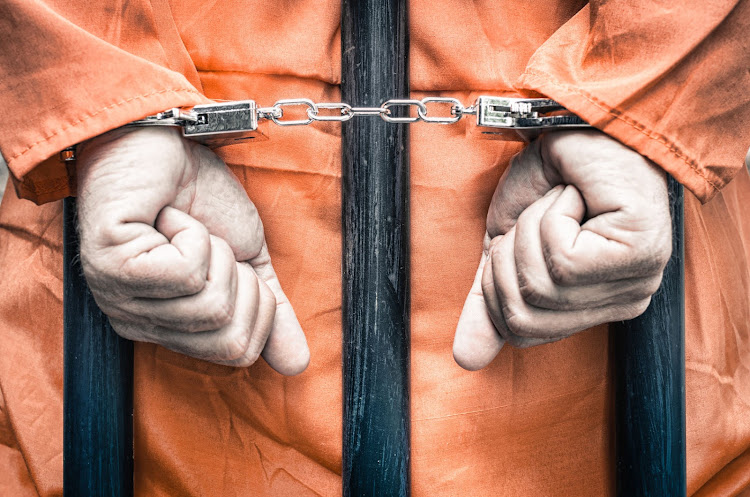 Criminal handcuffed and behind bars. Image: 123RF/viewapart